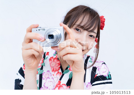 写真を撮る浴衣の若い女性 105013513