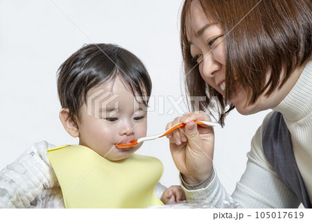 お母さんから離乳食を食べさせてもらう赤ちゃんのクローズアップ。育児、子育て、愛情イメージ お母さんから離乳食を食べさせてもらう赤ちゃんのクローズアップ。育児、子育て、愛情イメージ 105017619