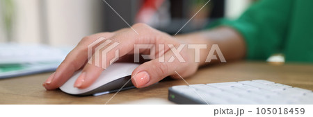 Close-up of woman's hand resting on modern wireless computer mouse. 105018459