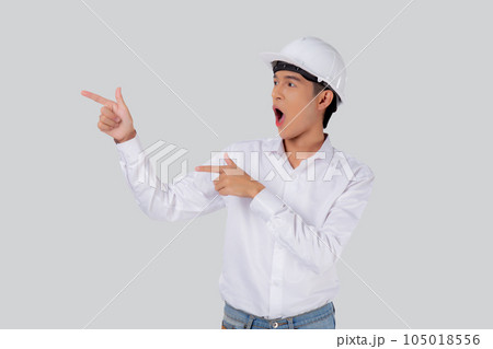 Portrait young asian man is engineer wearing helmet standing and excited. Portrait young asian man is engineer wearing helmet standing and excited. 105018556