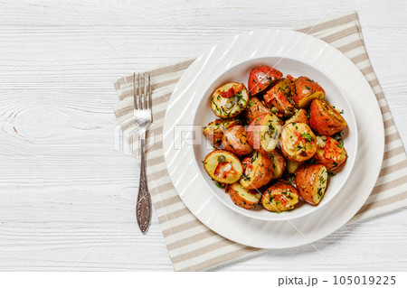 Herbs Garlic Potatoes in white bowl, top view Herbs Garlic Potatoes in white bowl, top view 105019225