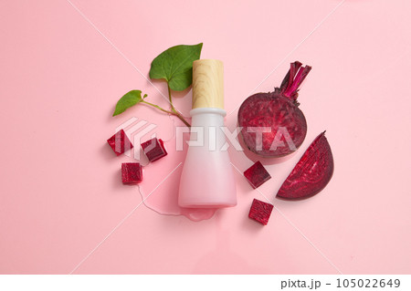 Mockup scene for advertising and branding cosmetic with beetroot ingredient. Pink bottle unbranded on pink background with beet slices and fish mint. Concept for cosmetic with natural extract 105022649