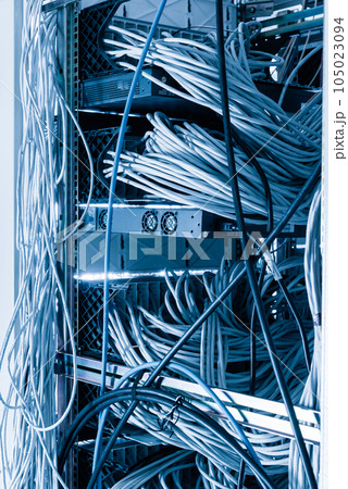 server room rack with tangled network cables creating messy untidy network system 105023094