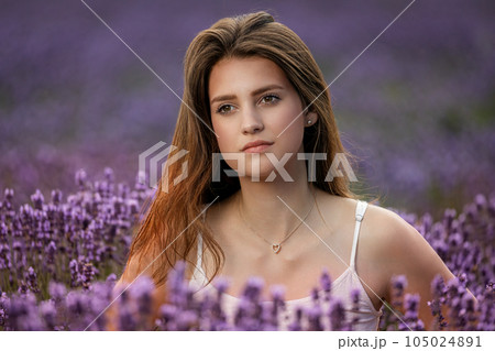 Closeup portrait of beautiful brunette girl posing in lavender field. Closeup portrait of beautiful brunette girl posing in lavender field. 105024891