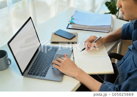 Asian man entrepreneur doing online data market analysis, using laptop in modern workplace Asian man entrepreneur doing online data market analysis, using laptop in modern workplace 105025669