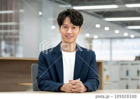 カメラ目線で笑顔のビジネスマン　カジュアルビジネスイメージ　ポートレート 105028100