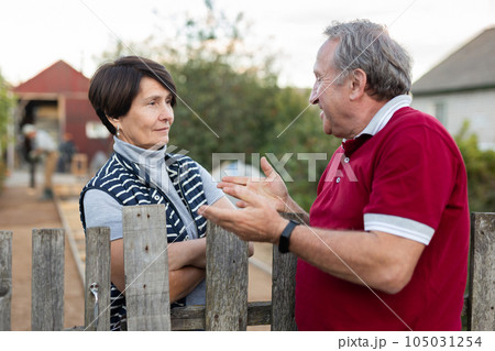 Two gardeners are having a friendly conversation outdoors 105031254