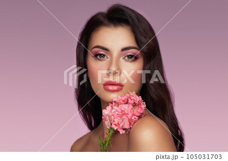 Beautiful young woman with a pink larkspur flower 105031703