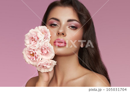 Beautiful young woman with a rose flower 105031704