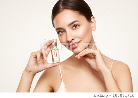 Woman holding a cosmetic jar of oil serum 105031716