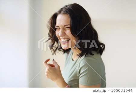 Cheerful women jumping or doing sports indoor, looking back at camera while moving with broad smile 105031944