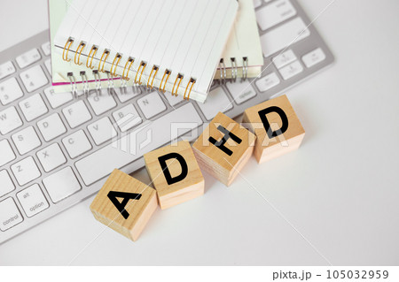 Abbreviation of ADHD on wood cube block with computer keyboard and note book on white table 105032959