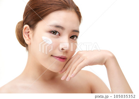 beautiful young woman with clean skin and moisturizing cream 105035352