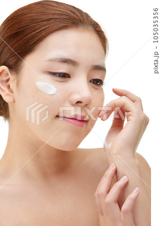 beautiful young woman with clean skin and moisturizing cream 105035356