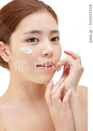 beautiful young woman with clean skin and moisturizing cream beautiful young woman with clean skin and moisturizing cream 105035358