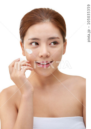 beautiful young woman with clean skin and moisturizing cream 105035359