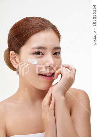 beautiful young woman with clean skin and moisturizing cream beautiful young woman with clean skin and moisturizing cream 105035364