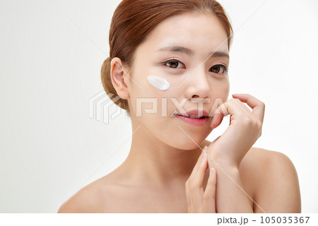 beautiful young woman with clean skin and moisturizing cream 105035367