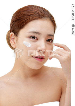 beautiful young woman with clean skin and moisturizing cream 105035374