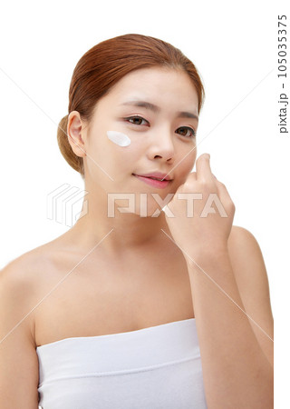 beautiful young woman with clean skin and moisturizing cream 105035375