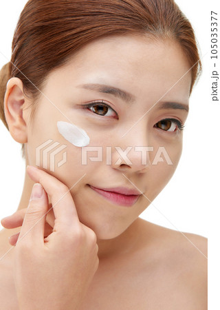 beautiful young woman with clean skin and moisturizing cream 105035377