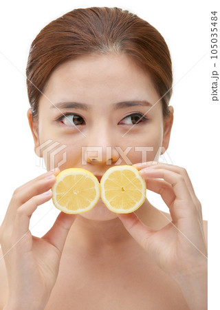 beautiful young woman with clean skin, moisturizing cream and holding a lemon beautiful young woman with clean skin, moisturizing cream and holding a lemon 105035484