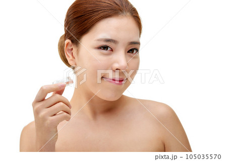 beautiful young woman with clean skin and moisturizing cream 105035570