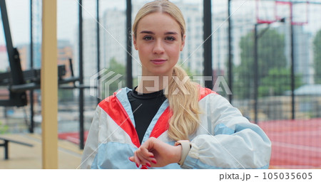 Young fitness woman looking at smartwatch outdoors athlete training equipment app. Healthy lifestyle concept. 105035605