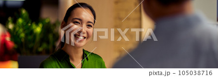 Young cheerful asian woman, female office worker giving some documents to her colleague and smiling while standing together in the modern office Young cheerful asian woman, female office worker giving some documents to her colleague and smiling while standing together in the modern office 105038716