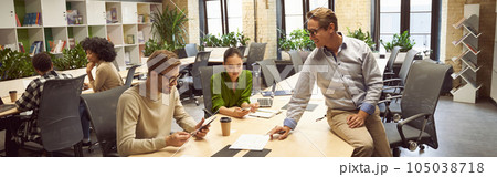 Sharing fresh ideas. Three young colleagues sitting at the desk in the modern coworking space, chatting and discussing new project, business people working together Sharing fresh ideas. Three young colleagues sitting at the desk in the modern coworking space, chatting and discussing new project, business people working together 105038718