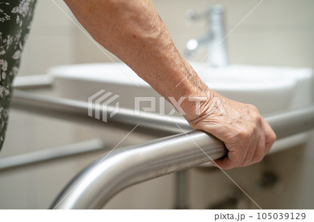 Asian elderly woman patient use toilet bathroom handle security in nursing hospital, healthy strong medical concept. 105039129