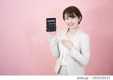 ピンクバックで黒い電卓を持って微笑む女性 ピンクバックで黒い電卓を持って微笑む女性 105039915