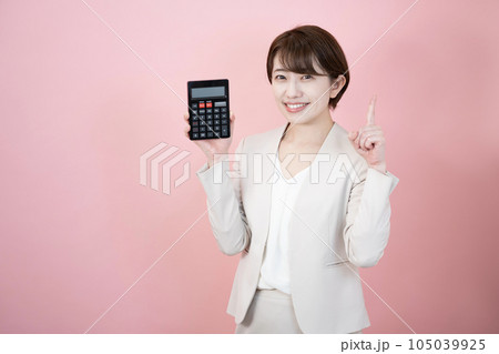 ピンクバックで黒い電卓を持って微笑む女性 ピンクバックで黒い電卓を持って微笑む女性 105039925