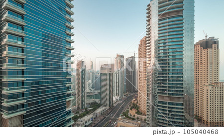 View of the Dubai Marina and JBR area and the famous Ferris Wheel aerial night to day timelapse 105040468