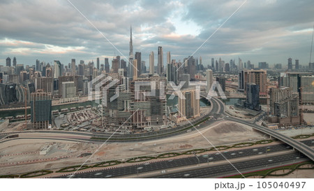 Panoramic skyline of Dubai with business bay and downtown district night to day timelapse. 105040497