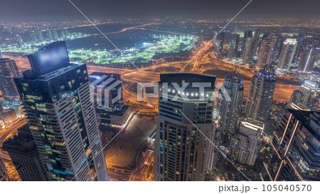 Panorama of Dubai Marina with JLT skyscrapers and golf course night timelapse, Dubai, United Arab Emirates. 105040570