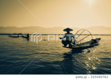 Myanmar travel attraction landmark - Traditional Burmese fisherman at Inle lake, Myanmar famous for their distinctive one legged rowing style 105040762