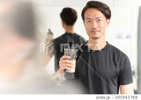 ドリンクを手に持つスポーツウェア着用の男性 ドリンクを手に持つスポーツウェア着用の男性 105041769