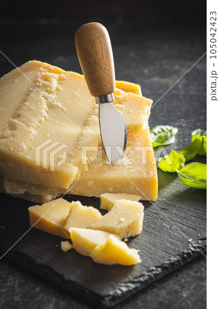 Tasty parmesan cheese on cutting board. Tasty parmesan cheese on cutting board. 105042423