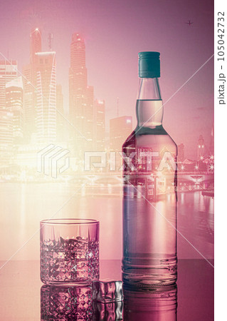 Bottle of liquor with the city skiline in the background at night. Bottle of liquor with the city skiline in the background at night. 105042732