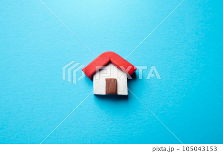 Miniature house on a blue background. Buying and selling housing. Real estate market review. Construction industry. Design and architectural services. Property insurance. 105043153