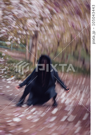 Dramatic young woman wearing black kimono and yellow glasses with cherry blossoms, sakura view Dramatic young woman wearing black kimono and yellow glasses with cherry blossoms, sakura view 105043443