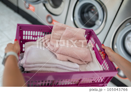 Woman in the public room to wash her cloths, self service commercial laundry and drying machine in a public room. 105043766