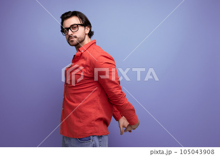 stylish european 35 year old man in a casual shirt is studying on a blue background with copy space stylish european 35 year old man in a casual shirt is studying on a blue background with copy space 105043908