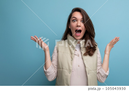 surprised caucasian young brunette woman with hair below her shoulders waving her hands in joy surprised caucasian young brunette woman with hair below her shoulders waving her hands in joy 105043930