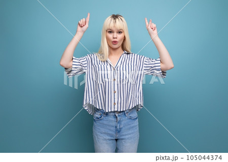 pretty european 20s woman in striped shirt showing hand up on studio background pretty european 20s woman in striped shirt showing hand up on studio background 105044374