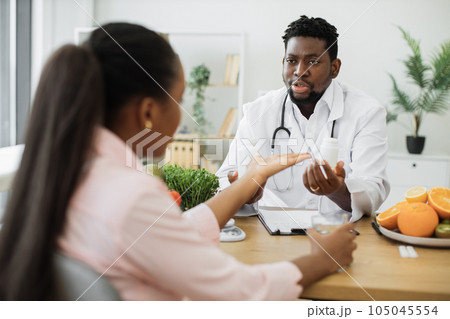 African american doctor giving medicine to patient in clinic 105045554