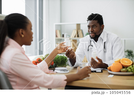 Professional giving dietary supplements to patient at work 105045556