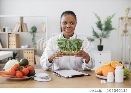Specialist holding container with microgreens in workplace Specialist holding container with microgreens in workplace 105046133