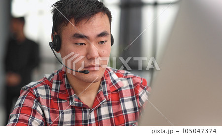 Young asian businessman working on laptop computer wearing headphone at home Young asian businessman working on laptop computer wearing headphone at home 105047374